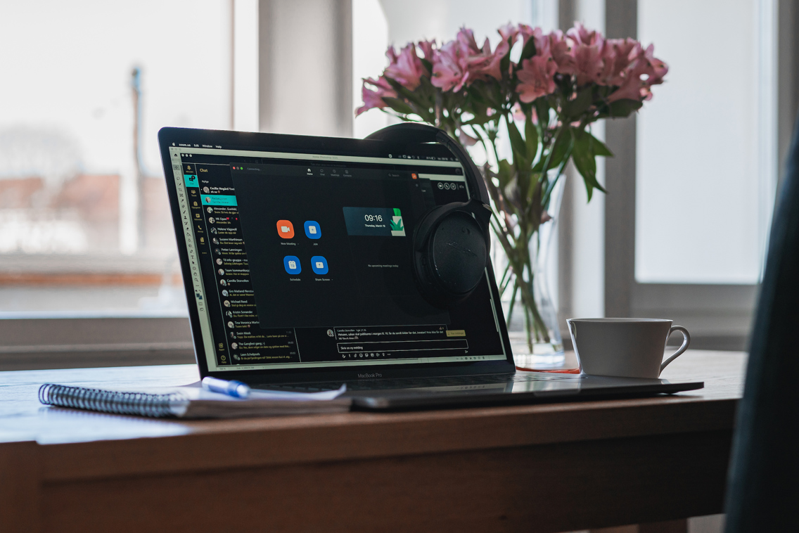 Illustrasjonsfoto av PC på et skrivebord, sammen med kaffekopp og blomster.