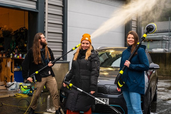 Foto av tre personer som står foran en nyvasket bil med utstyr fra AVA of Norway.