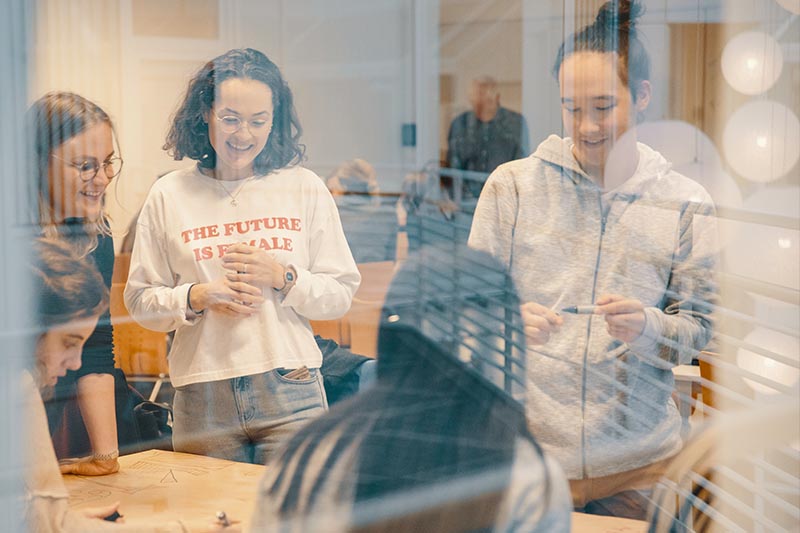 Studenter, to jenter en gutt, gjør gruppearbeid.