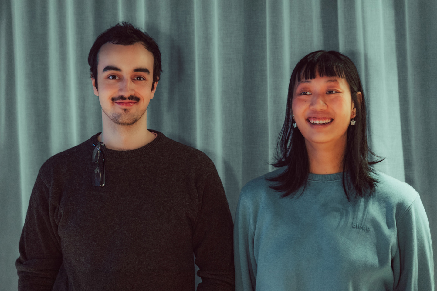 Portrett av to studenter foran en grønn gardin.