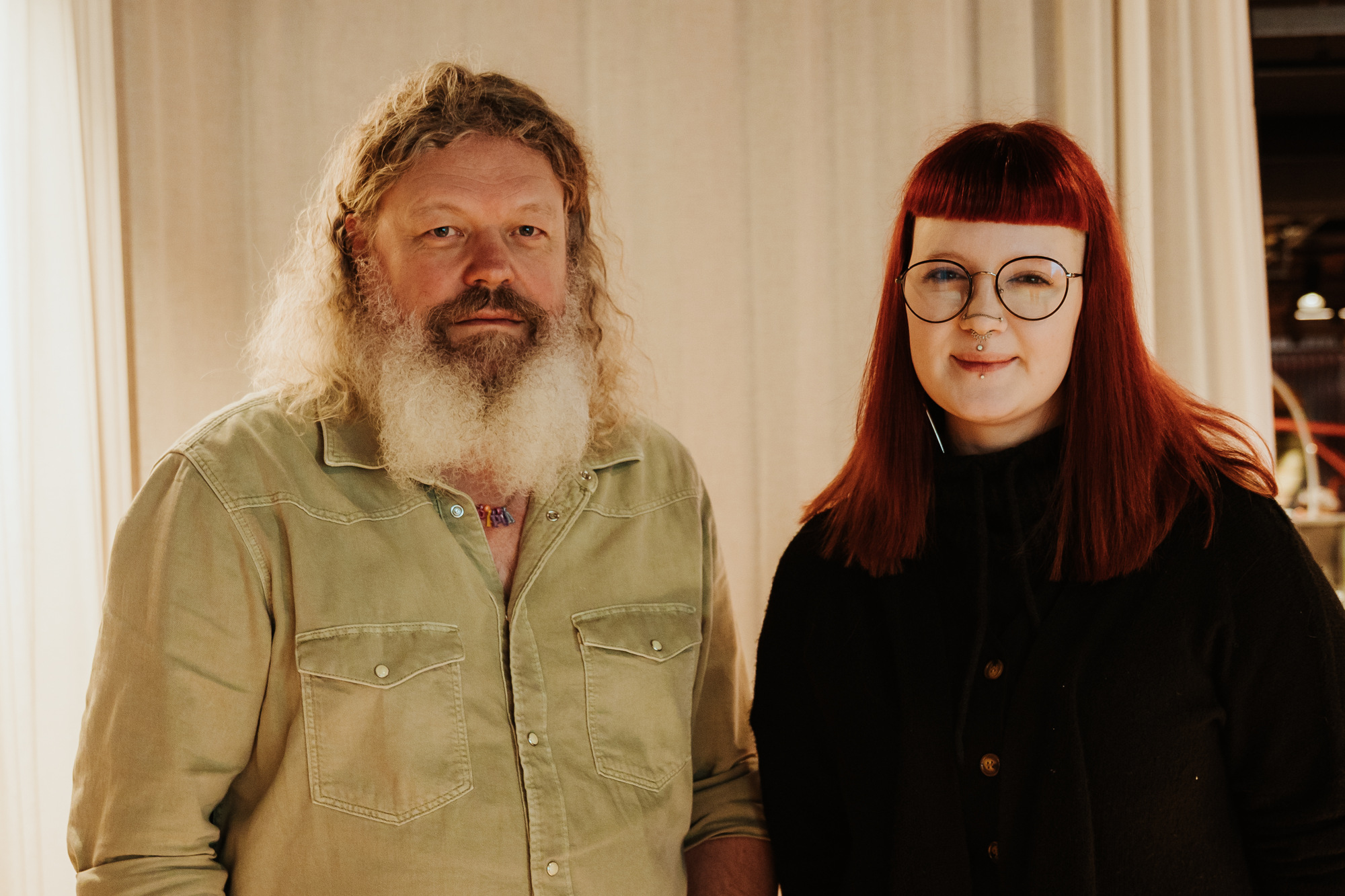 Portrett av Torgeir og Ronja som står foran en gardin.