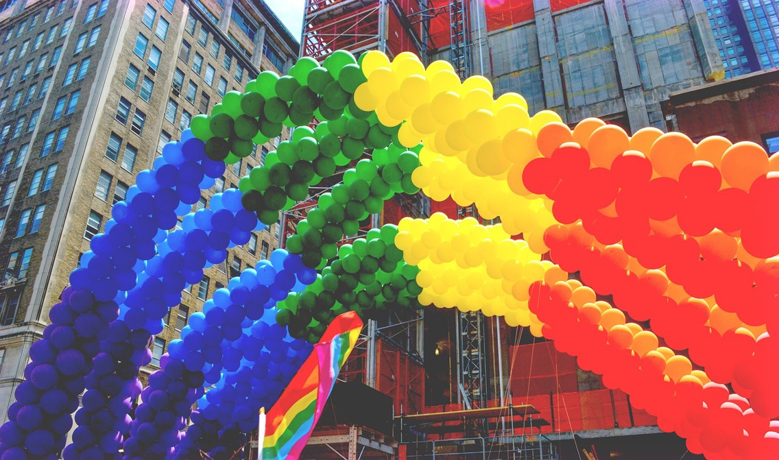 Ballonger i pride-farger former en regnbue