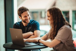 Foto av to studenter som sitter foran en pc