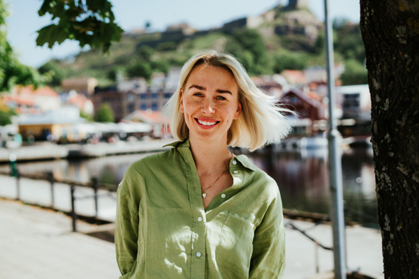 Smilende ung kvinne med Halden marina i bakgrunnen.