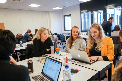 Foto av fire kvinnelige studenter rundt et bord.