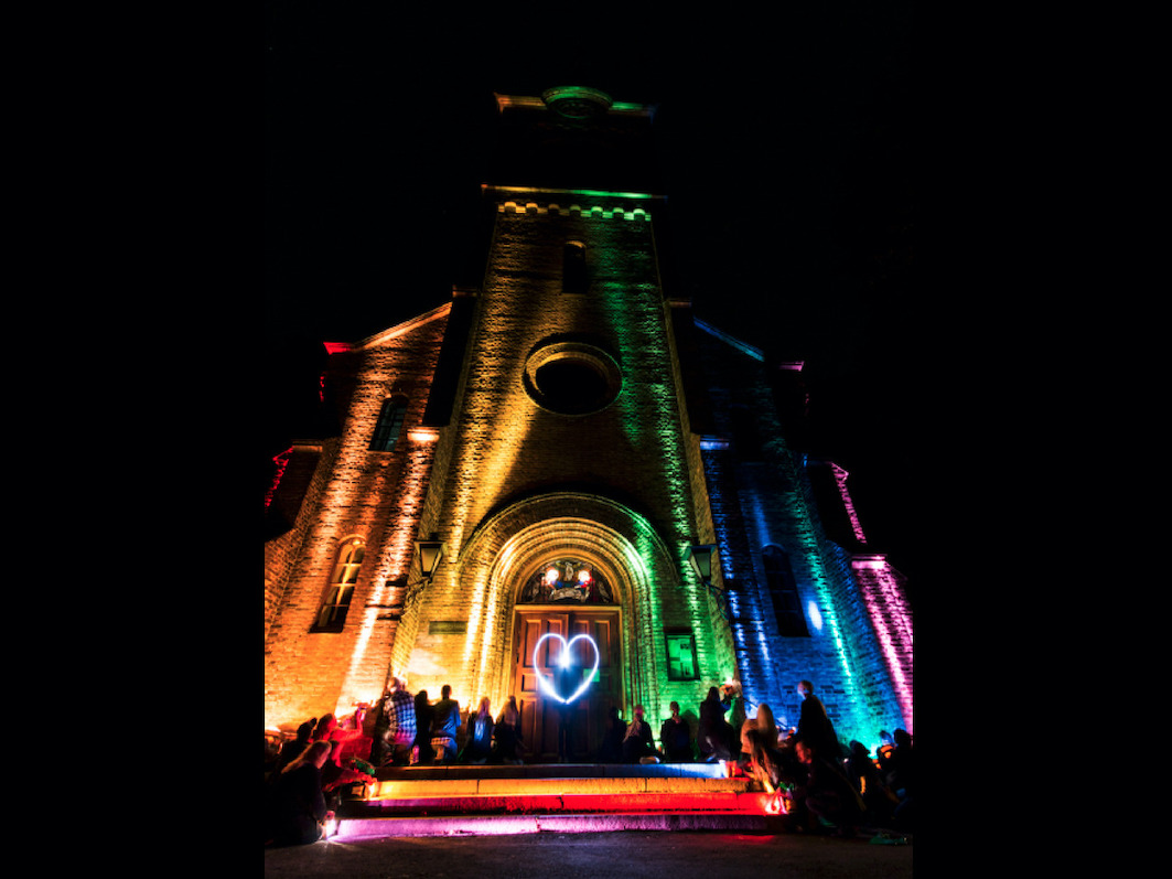 Fronten av Sofienberg kirke, som er lyssatt i alle regnbuens farger og på døren er det et lysende hjerte