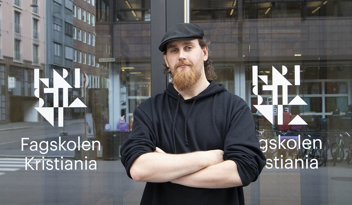 Foto av student foran inngangsparti på Fagskolen Kristiania.