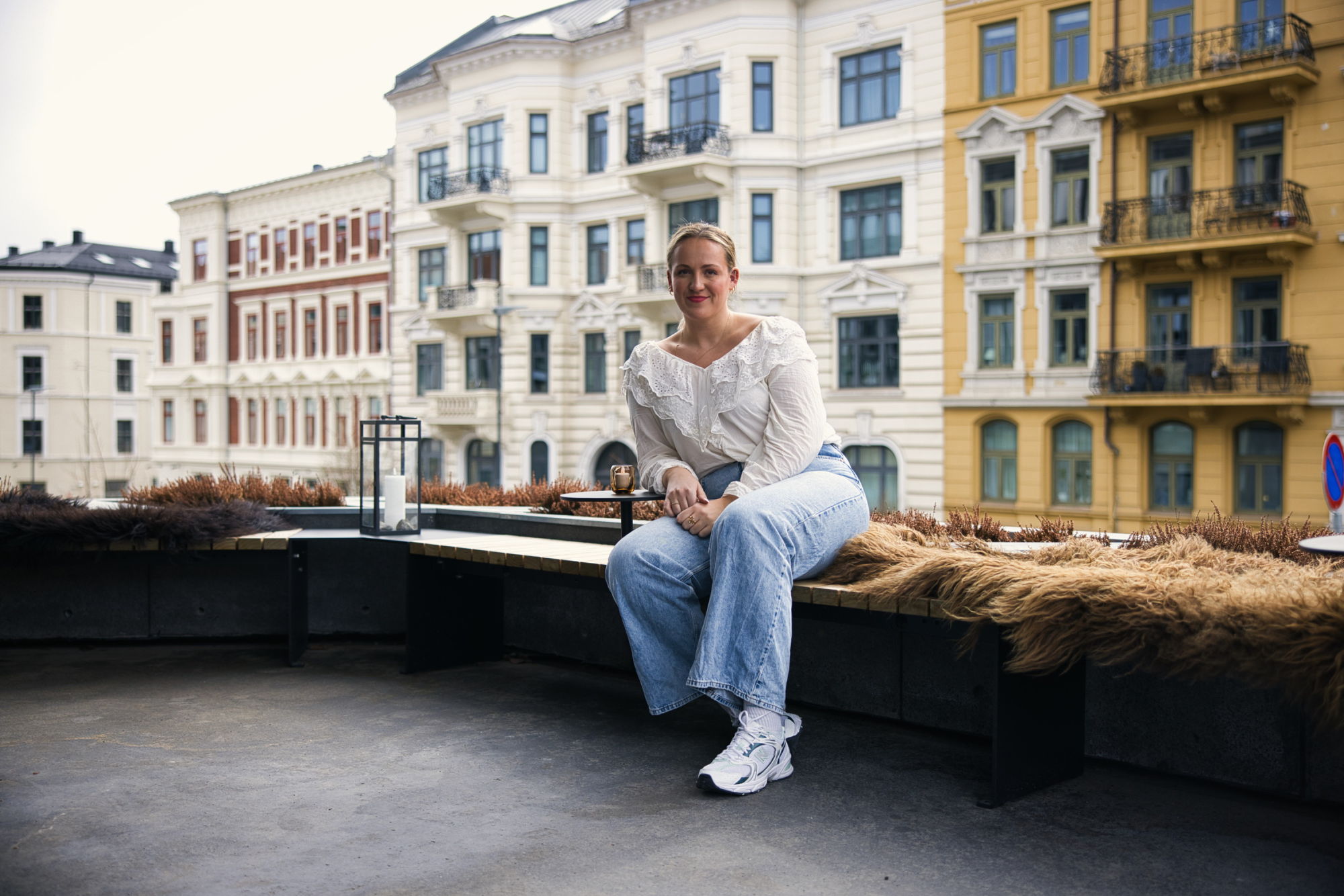 Frida sitter på en terrasse foran murhus i Oslo.