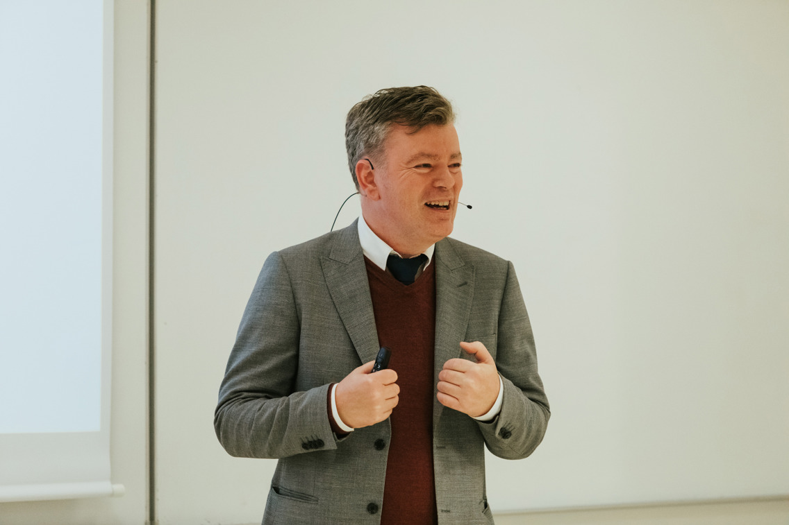 Kjell Ove Ernes smiler mens hans snakker på tiltredelsesforelesningen
