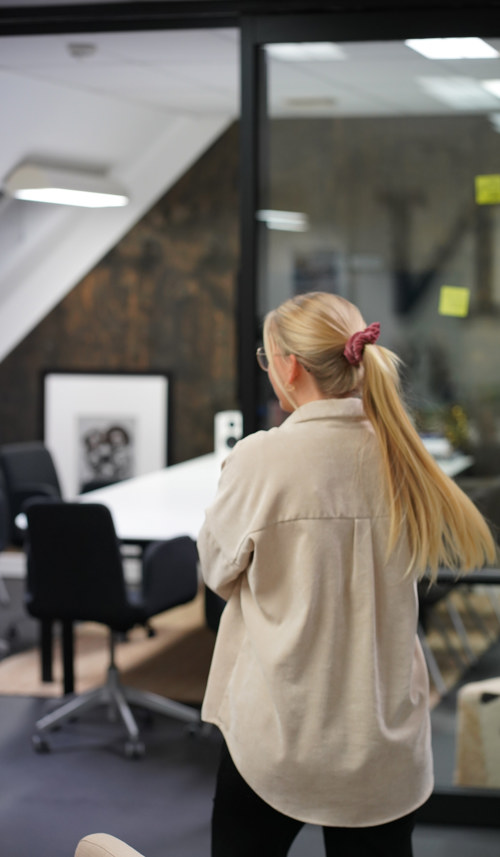 Eline Langøy Brattsli på kontoret til S & B-N der hun nylig har fått jobb. På bildet ser man baksiden av Eline, med en lang blond flette