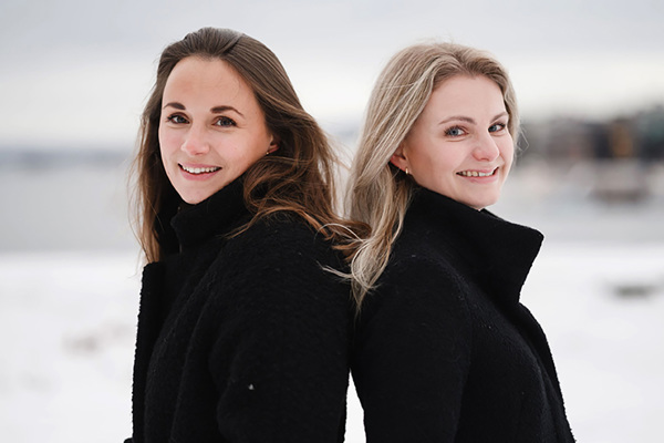 Helene og Cathrine står i et stort, lyst landskap.