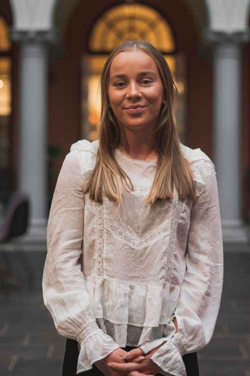 Foto av Liv Karin utenfor campus i Oslo. Smiler til kamera.