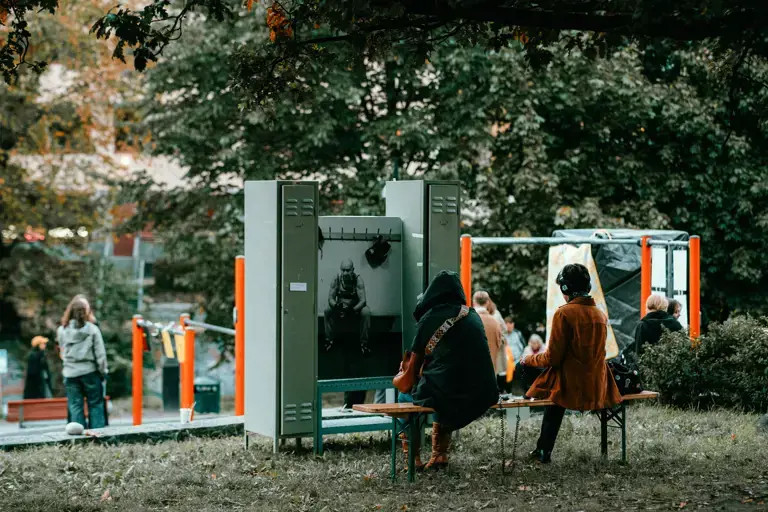 To mennesker på en benk på Grønland som ser på en kunstutstilling i parken