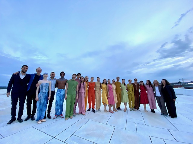 Rekke av 22 mennesker i fargerike klær på Operataket.
