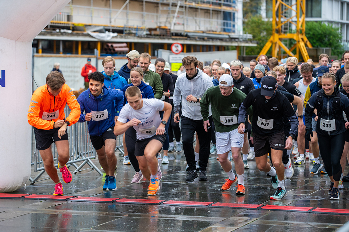 Mange mennesker krysser startstreken i det løpet begynner på Torgallmenningen i Bergen.