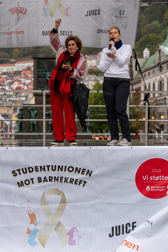 Foto av Trude Drevland og student på scenen.