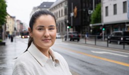 Nicoline står ved en vei og ser inn i kamera