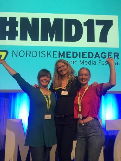 Tre kvinner som feirer på en scene med #NMD17 i bakgrunnen