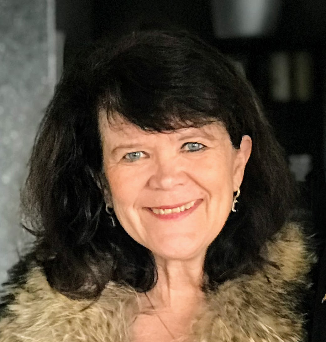 Foto av Anne Linda Løhre som har jobbet på Høyskolen Kristiania i tjue år. Hun har mørkt hår og et stort smil. 