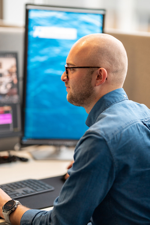 Isac sitter i kontorlandskapet og redigerer video om et par som lever som på 1800-tallet