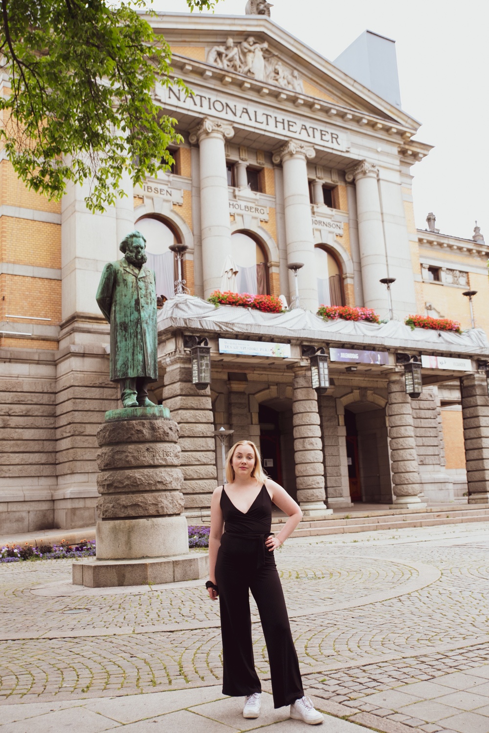 Dagny Backer foran det ærverdige Nationaltheatret, og statuen av Ibsen. 
