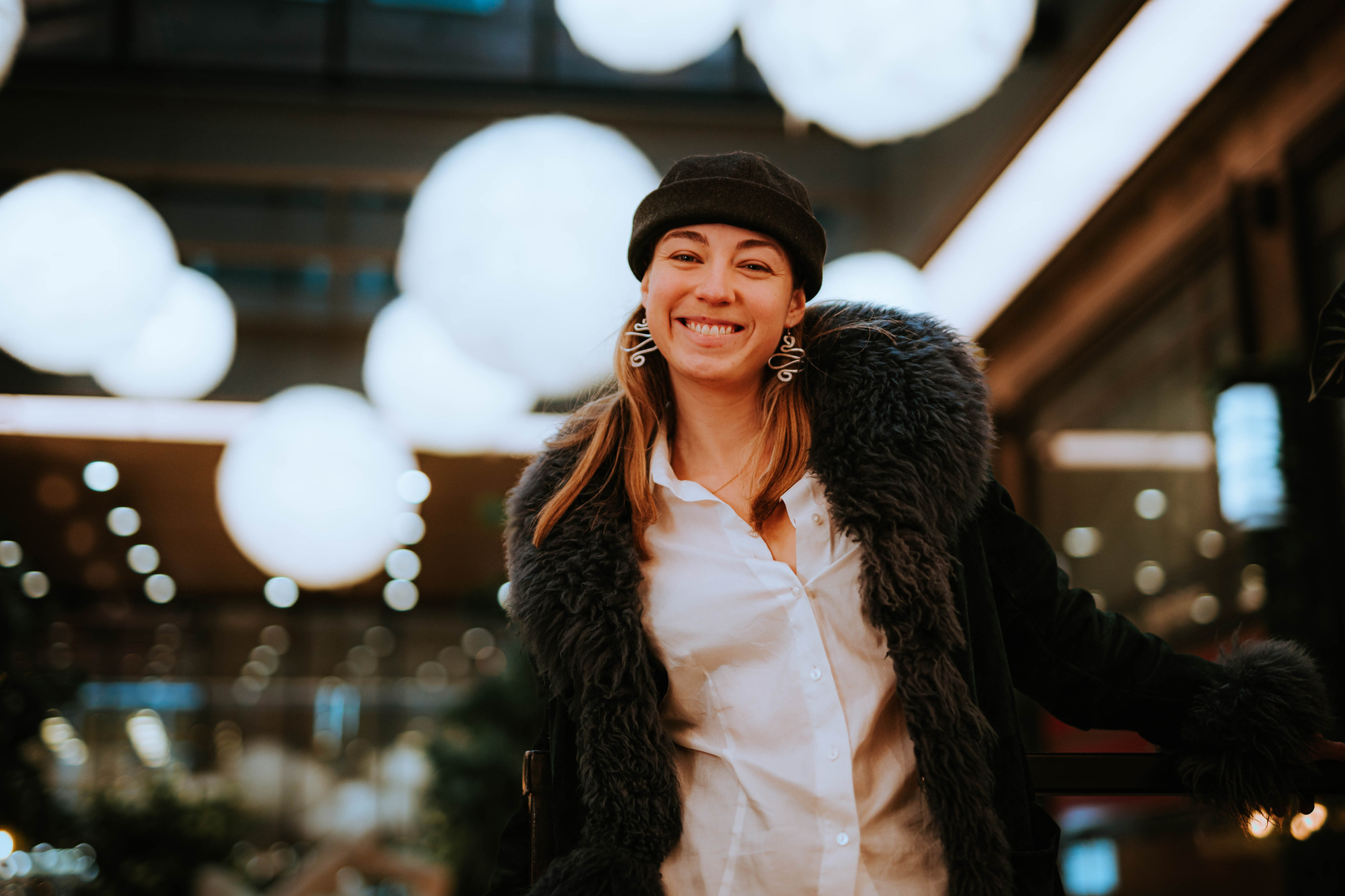 Portrett av artisten RABO som smiler med masse lys i bakgrunnen. 