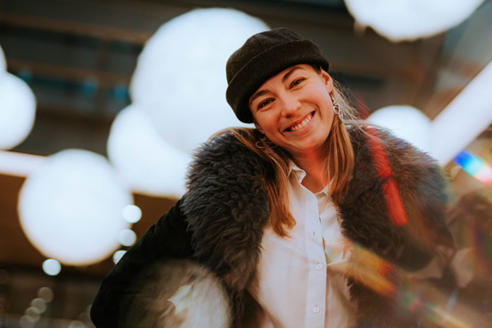 Portrett av artisten RABO som smiler, med lys i bakgrunnen.