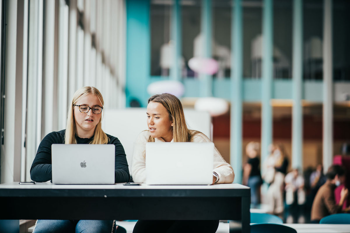 To studenter som sitter og jobber på campus i Bergen 