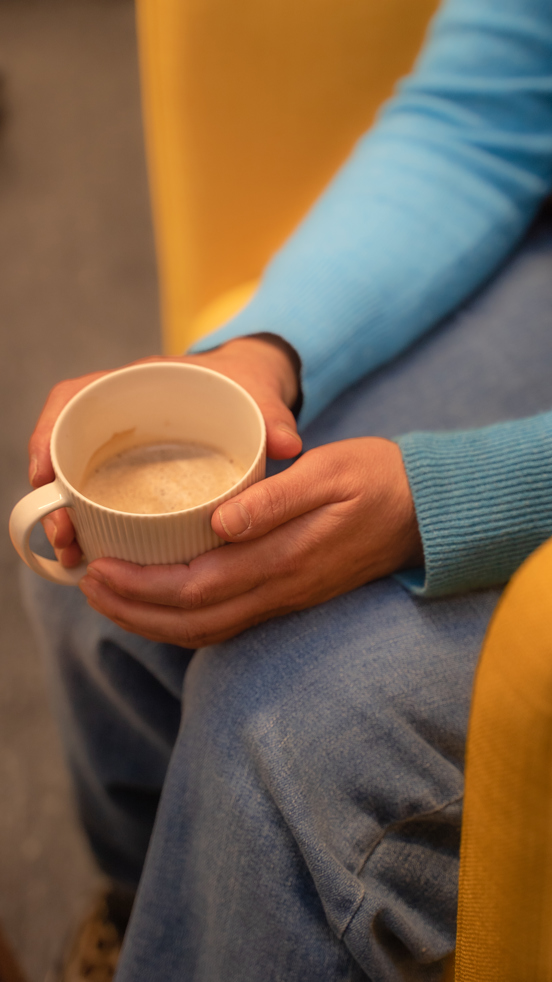 Nærbilde av Tone sine hender med en kaffekopp