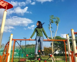 En kvinne som sitter på toppen av et lekestativ