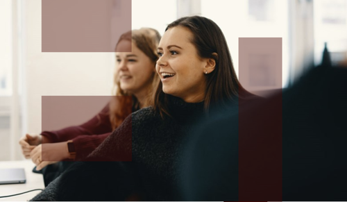 Foto av to kvinnelige studenter som følger undervisning.