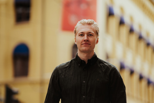 Mann foran gult murhus.