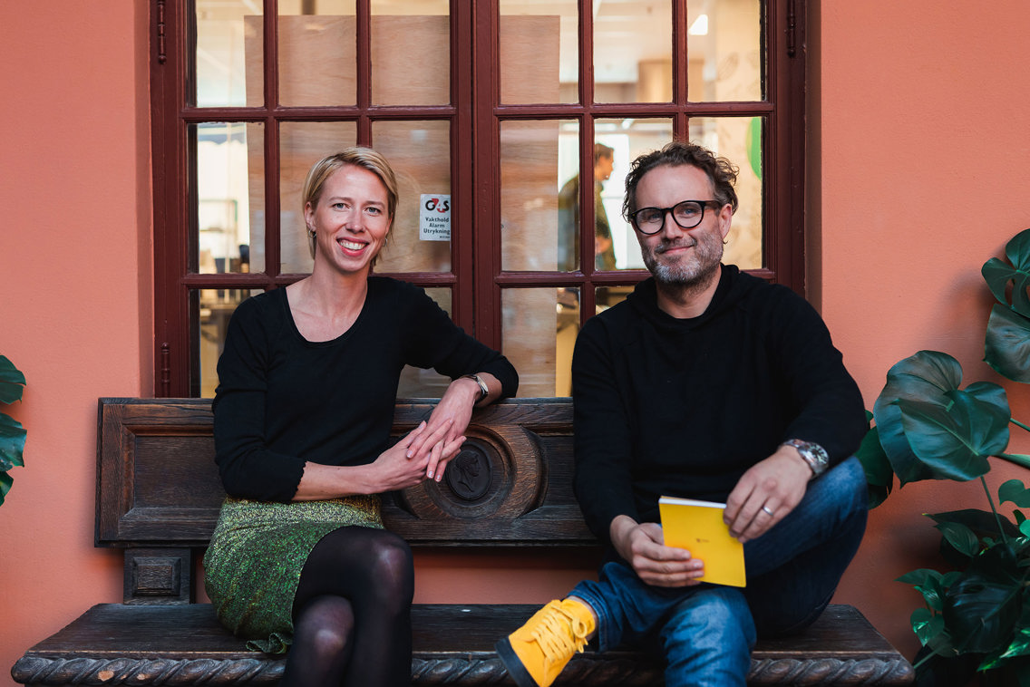 Foto av Tevje og Nora sittende ved siden av hverandre foran et vindu.