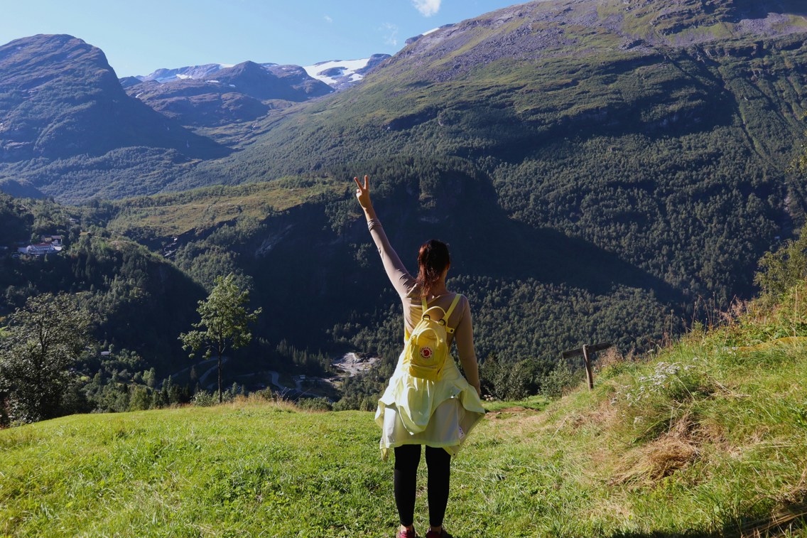 En dame på skogstur viser peace-tegnet