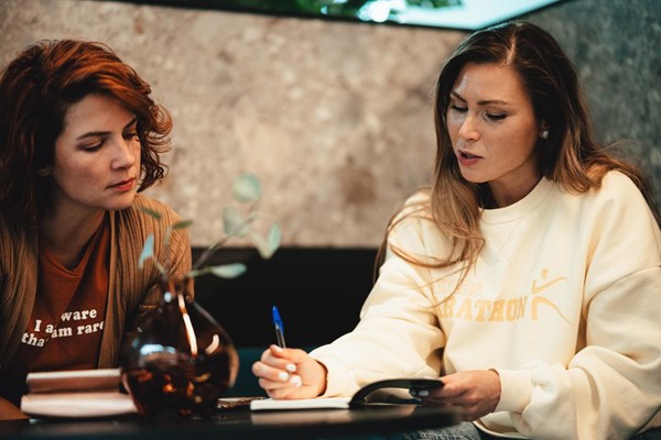 To kvinnelige studenter som sitter og jobber på kafé