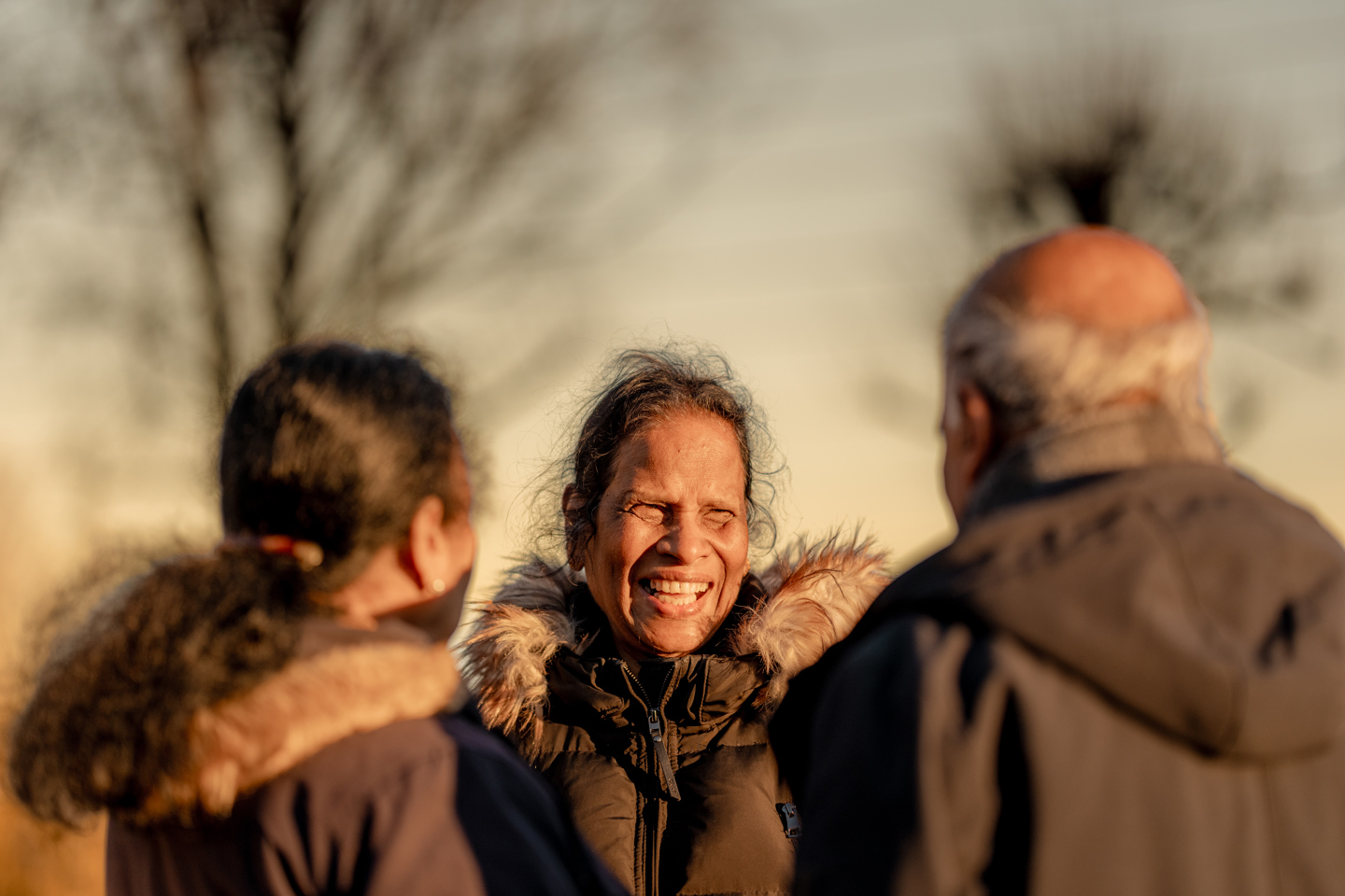Tre personer står ute og snakker sammen 