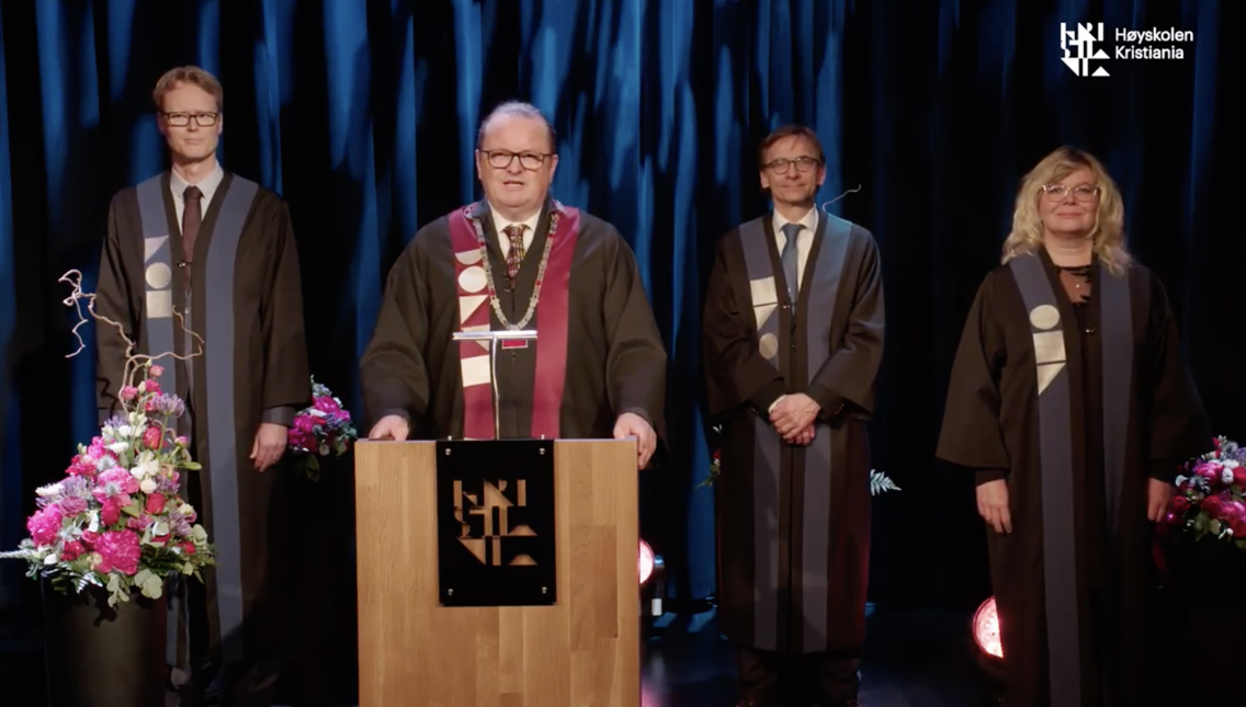 Skjermdump fra sendingen hvor rektor står på podiet
