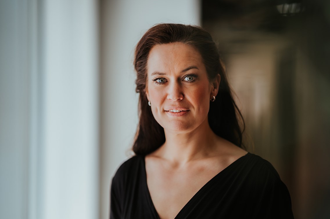 Camilla Gramstad, bærekraftsjef i Elkjøp Nordic, smiler direkte å kamera. Hun har på seg en sort genser.