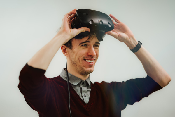 Smilende voksen mann med VR-briller