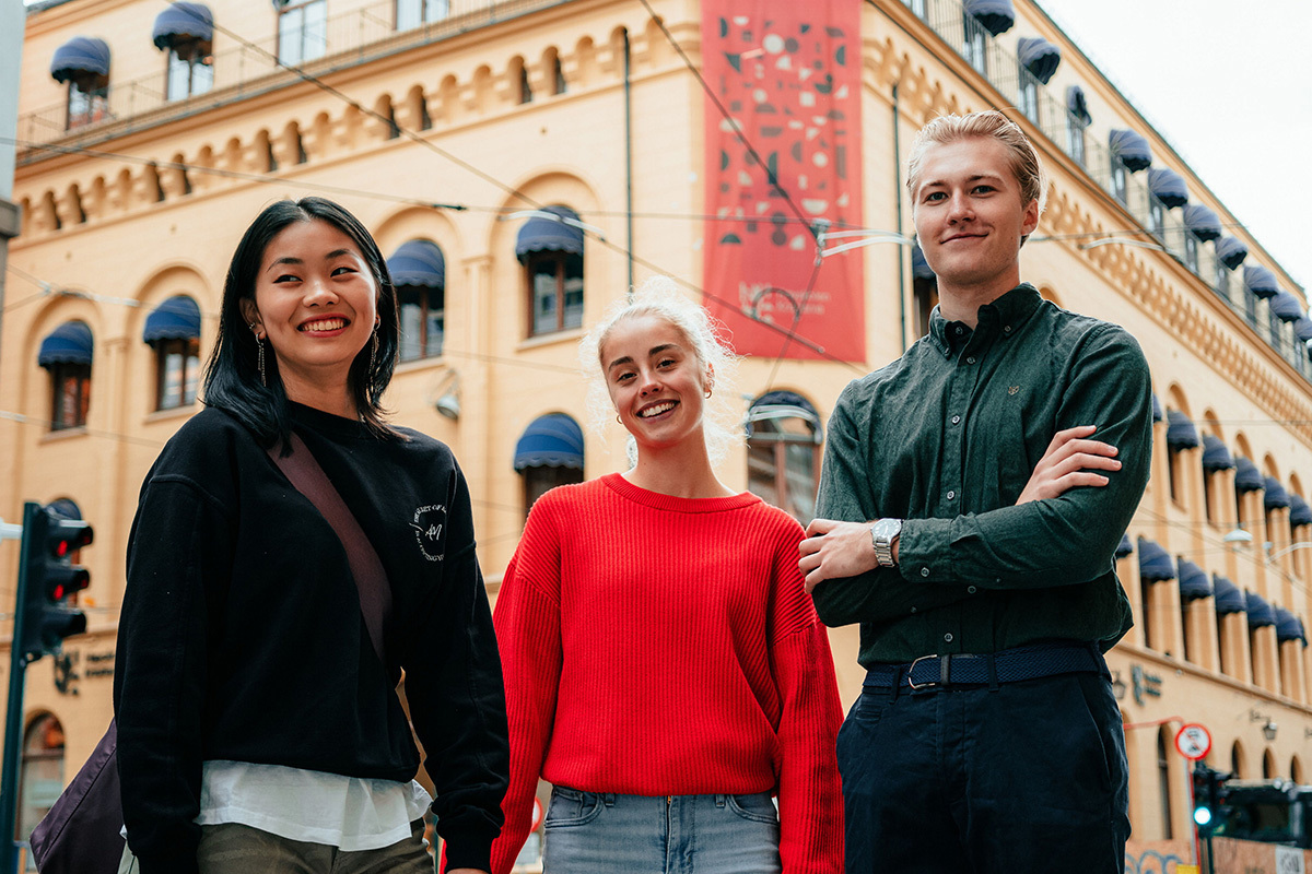 Tre studenter foran Kristianias hovedbygg i Kirkegata i Oslo.