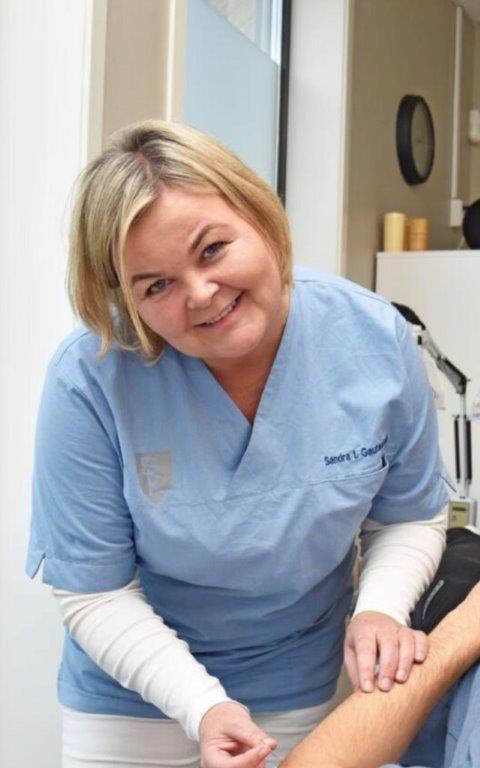 Sandra Gautestad, akupunktør i Vennesla. Foto av henne med pasient under akupunkturbehandling.