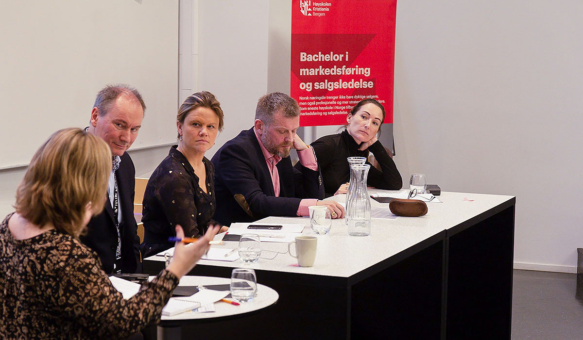 Fem deltakere på paneldebatten, nærbilde. De ser konsentrerte ut.