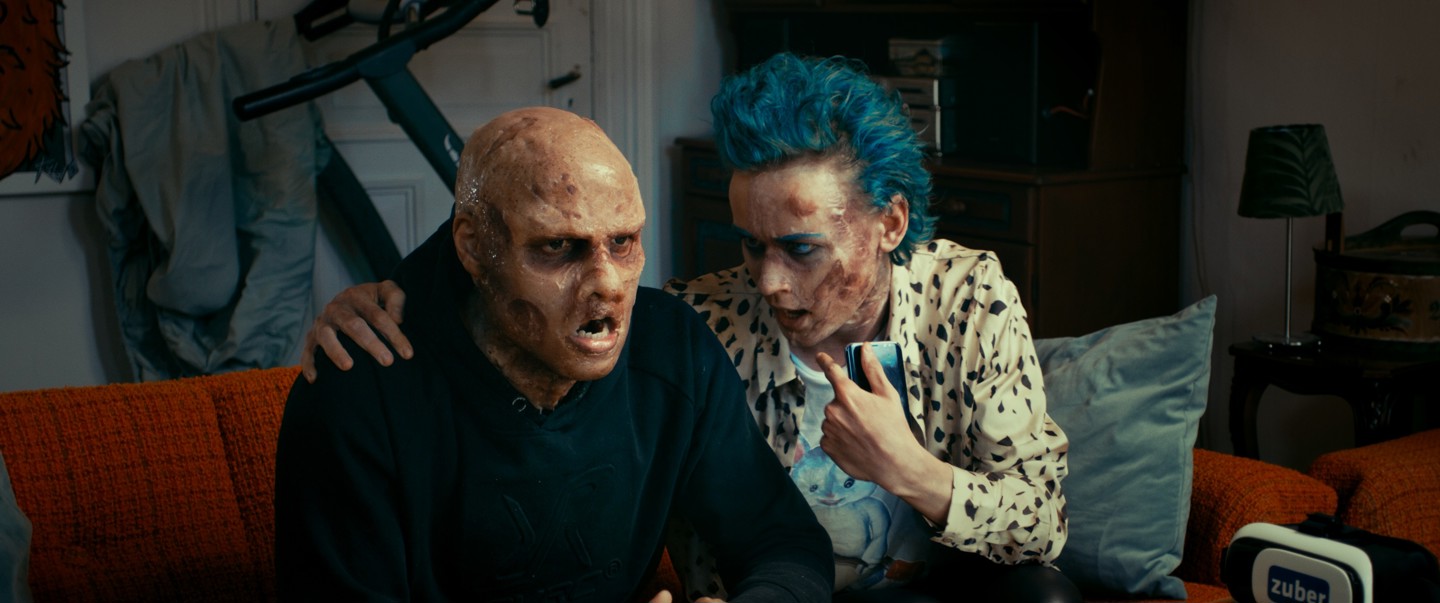 Stillbilde fra filmen, to zombier sitter i en sofa.