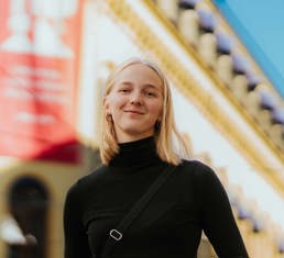Kvinne står foran Kristianias undervisningsbygg i Kirkegata
