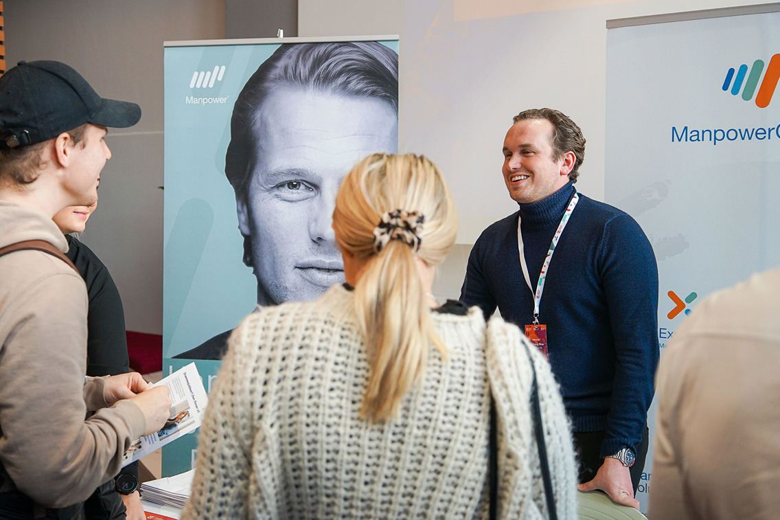 Fotografi som viser Henrik Børhaug Moe som står på stand under Karrieredagen ved Høyskolen Kristiania.