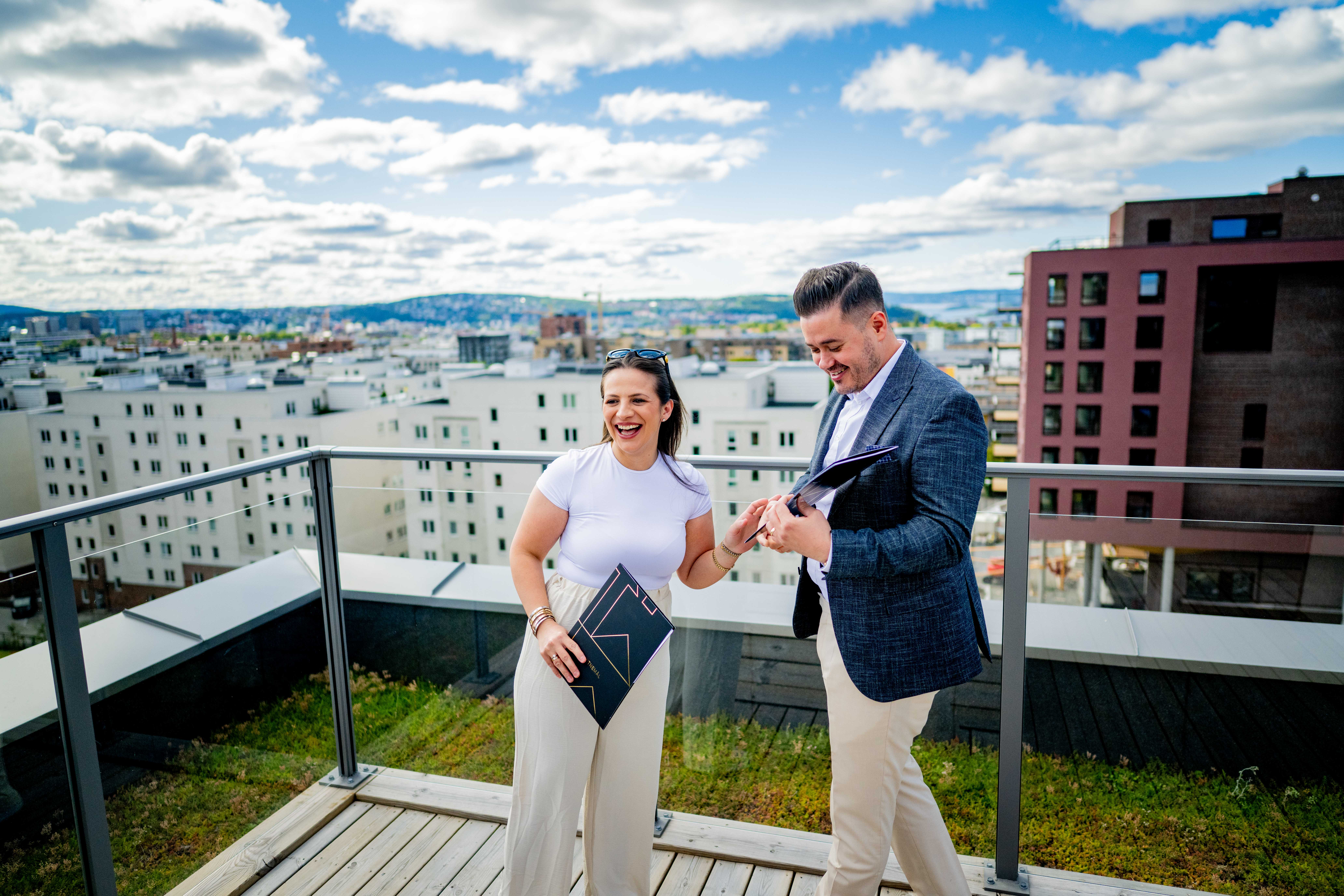 Funda og Ramadan med vitnemålene sine på en takterasse med utsikt over Oslo.