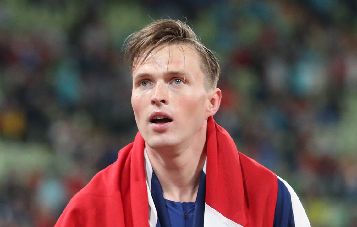 Karsten Warholm omtullet av det norske flagget etter EM-seier på 400-meter i München