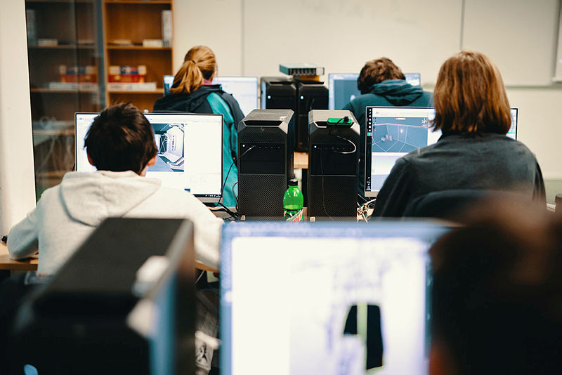 Foto av bilde bakfra et klasserom som holder på med spillutvikling
