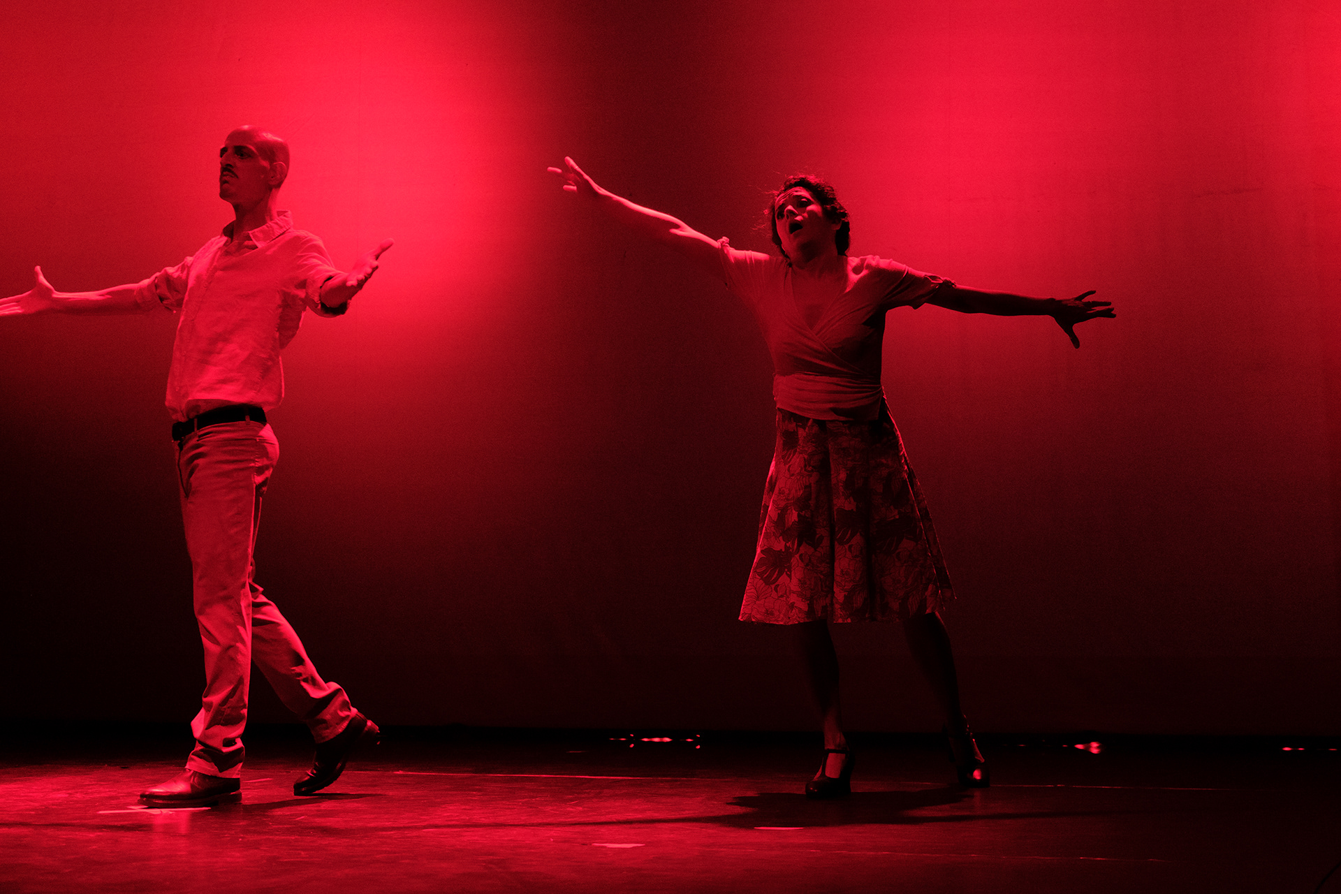 To skuespillere danser på scenen, bakgrunnen er rød