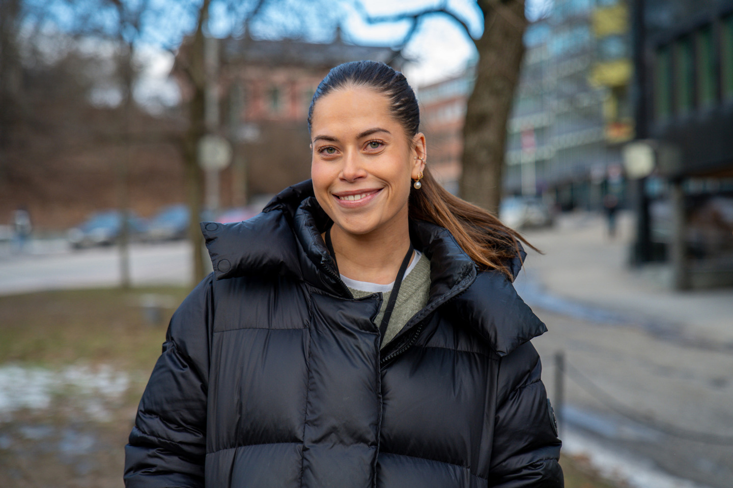 Portrett av Madelen som står utendørs og smiler. 